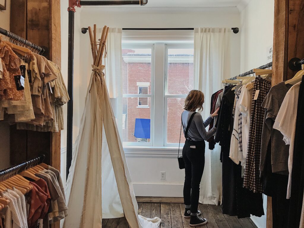 girl browsing clothing in a vintage shop - Second hand Cologne