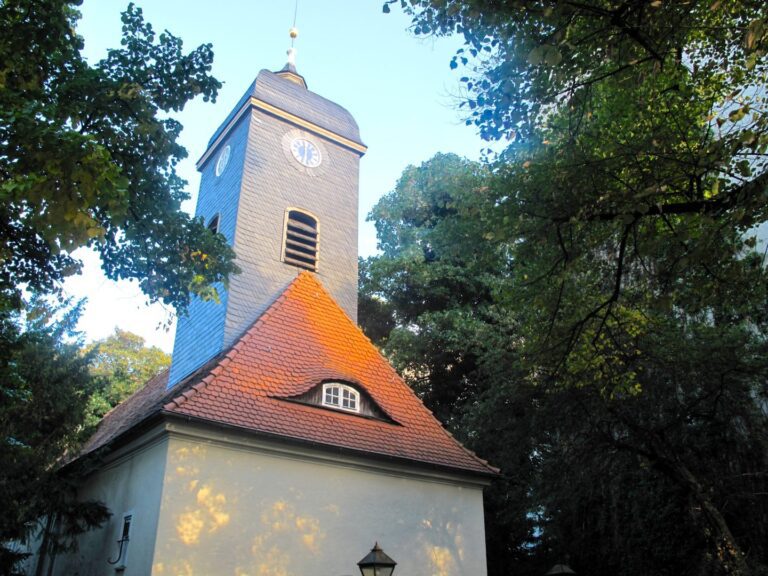 Historic church tower surrounded by green trees