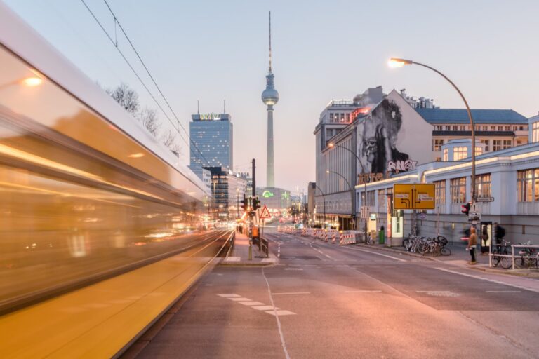 Berlin TV Tower with street art and tram passing through Alexanderplatz