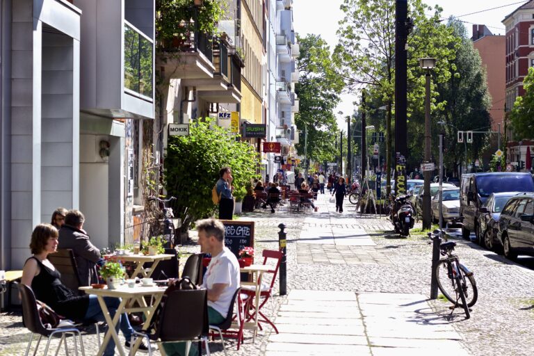 Lively street scene with cafes and people in Berlin neighborhood