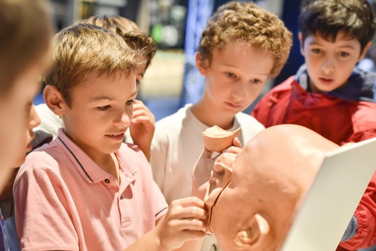 Kids exploring a human anatomy model at a science museum