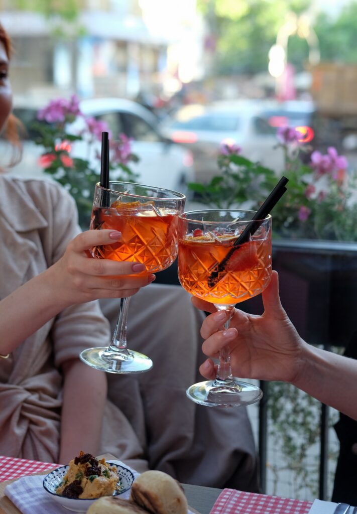 Best Coffee Spots in Cologne: A Quick Guide - two people making a toast with Aperol Spritz