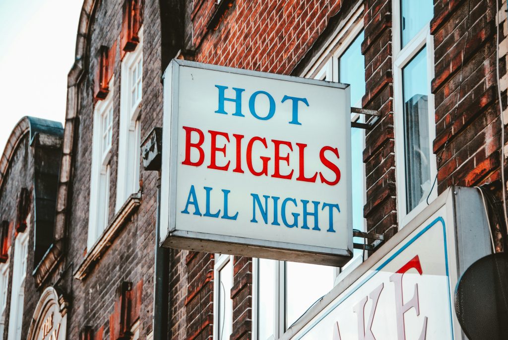 Sign of Beigel Bake bakery offering hot beigels all night in London