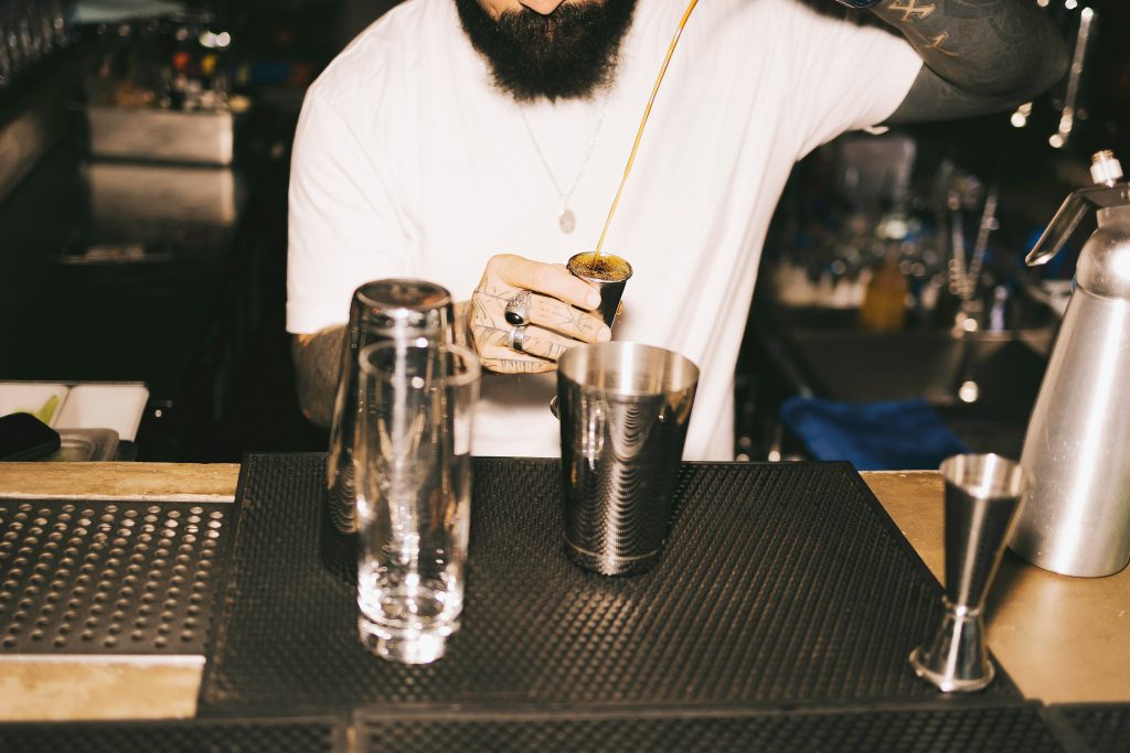Cool bars in Frankfurt: Bartender pouring syrup into jigger at a cocktail station