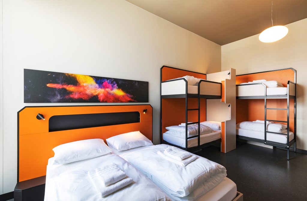 Bright family room with double bed, bunk beds, and modern orange design
