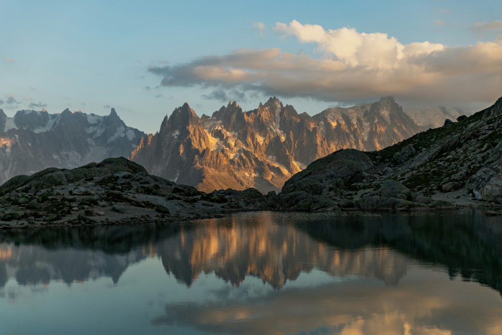 Goldene Gipfel des Mont-Blanc-Massivs spiegeln sich in ruhigem Alpensee bei Genf