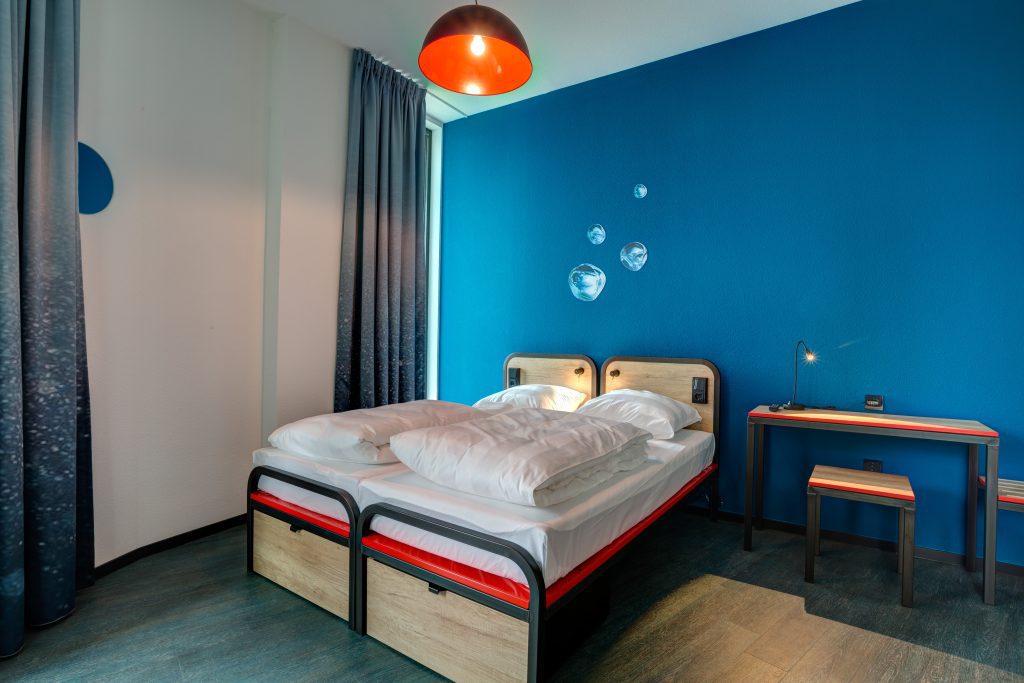 Cozy twin room with double bed and cool bubble art on the wall