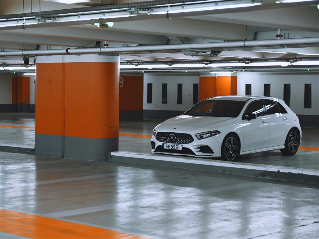 White car parked in clean orange indoor garage with bright lighting