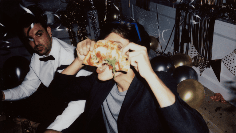 Partygoer eating late night pizza after drinks