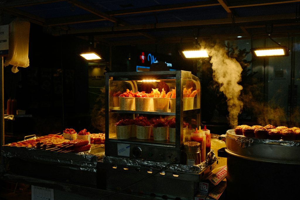 Dampfender Street-Food-Stand in Berlin mit Spießen und Snacks bei Nacht