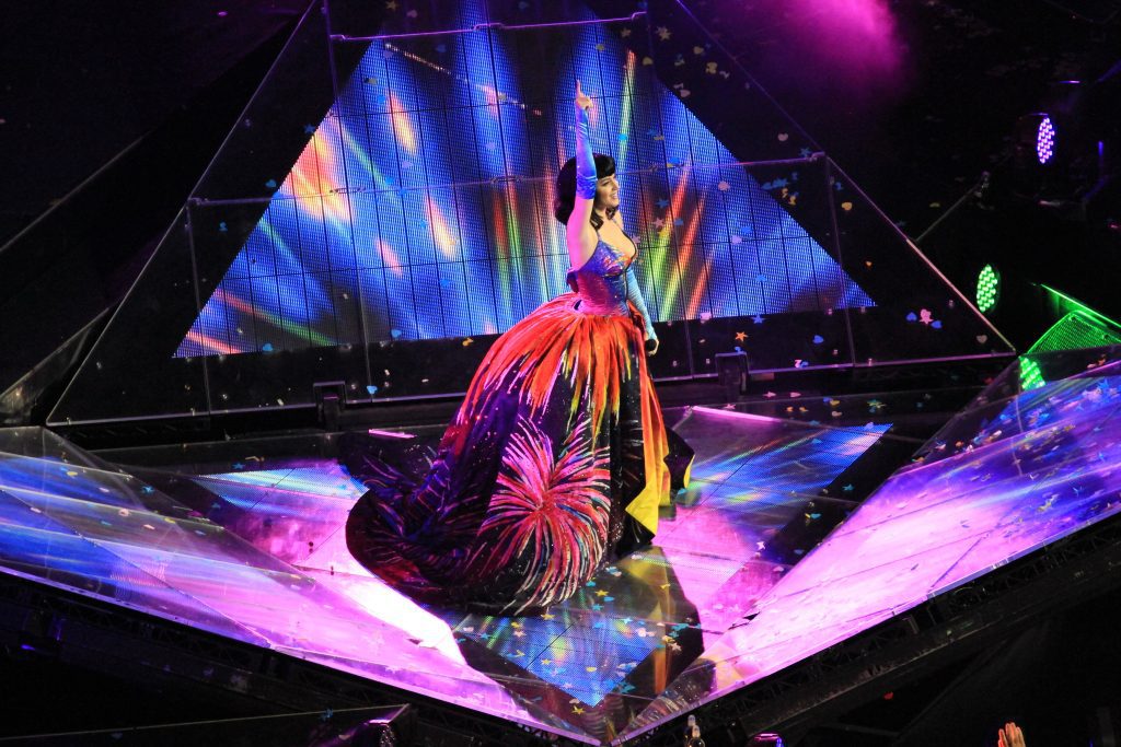 Concerts in Paris: Singer in a colorful firework dress on stage with bright lights