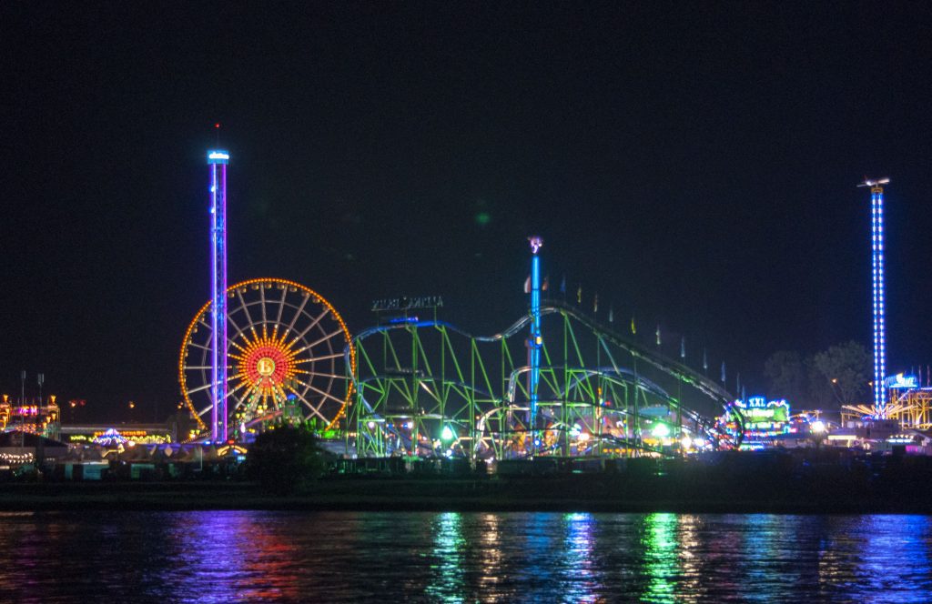 Düsseldorfer Karneval: Bunte Kirmesfahrgeschäfte bei Nacht am Flussufer
