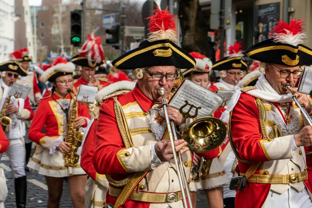 Düsseldorfer Karneval Karnevalsband in roten Uniformen spielt Musik auf den Straßen