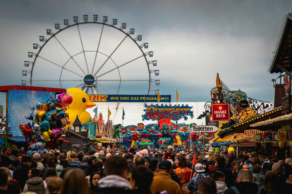 Freimarkt Bremen: Crowds enjoying rides and fun at Freimarkt Bremen with Ferris wheel view