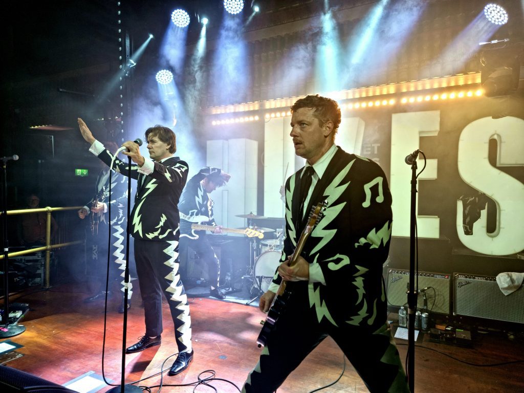 The Hives rocking the stage in their wild black-and-white suits
