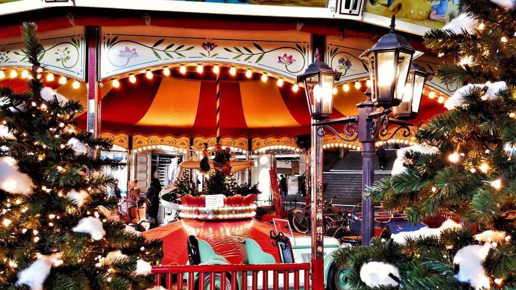 Leipzig Weihnachtsmarkt: Kinderkarussell mit Lichtern und Tannen mitten auf dem Weihnachtsmarkt.