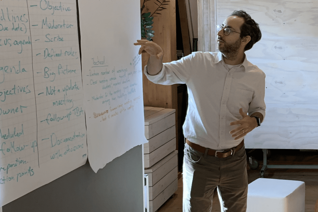 Eric erklärt Notizen bei einem Teammeeting
