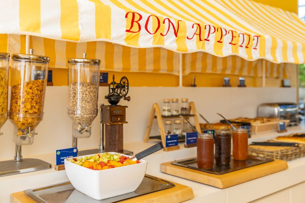 Cereal dispensers and fruit salad at breakfast buffet