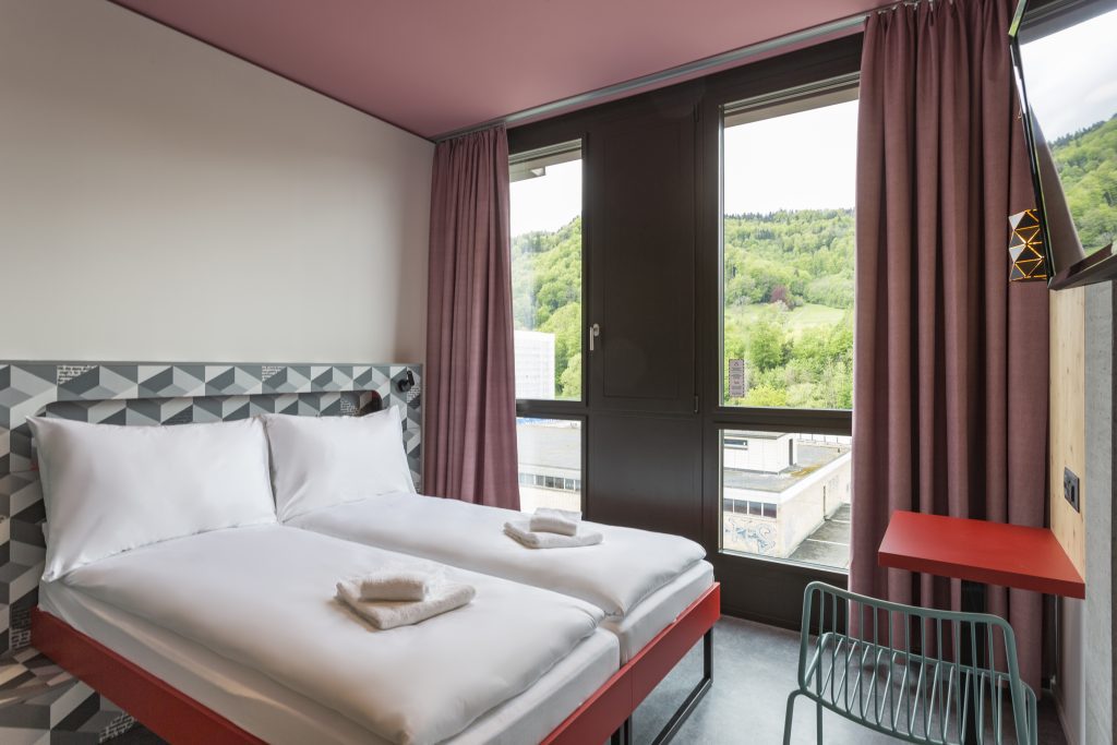 Double room with a double bed, big window, a desk and a chair