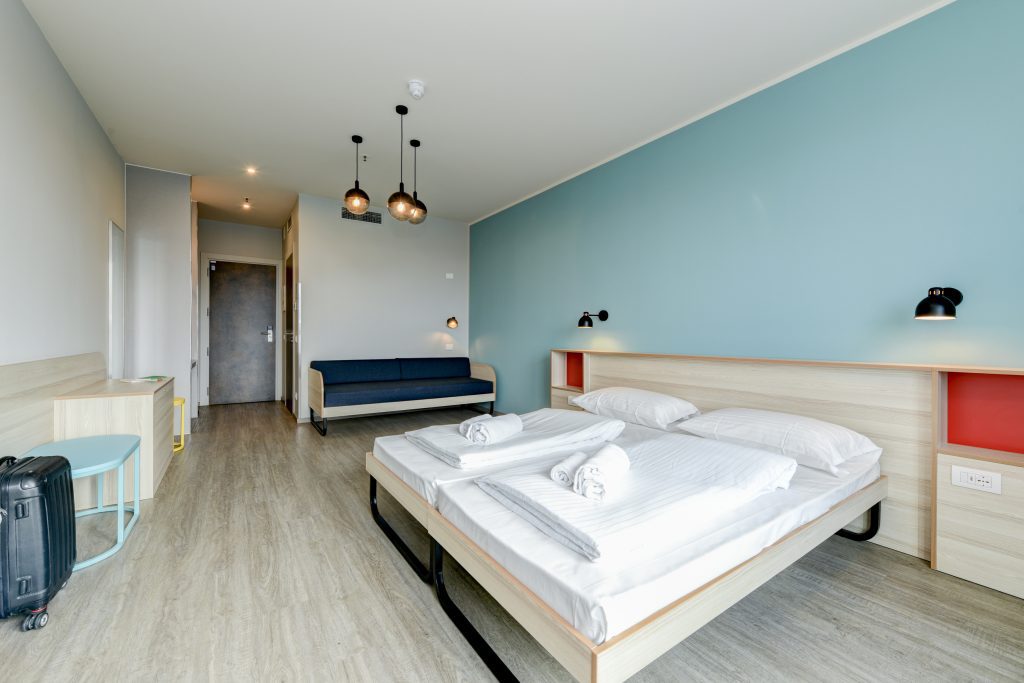 Triple room with double bed, a sofa bed and light blue wall