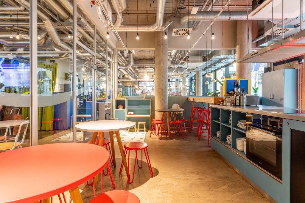 A guest kitchen with light blue and red furniture