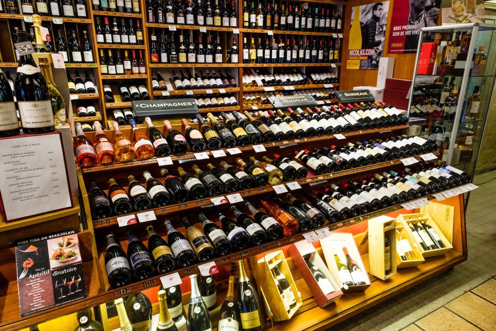 Les Halles de Lyon Paul Bocuse : Bouteilles de vin exposées sur des étagères à l’intérieur des Halles
