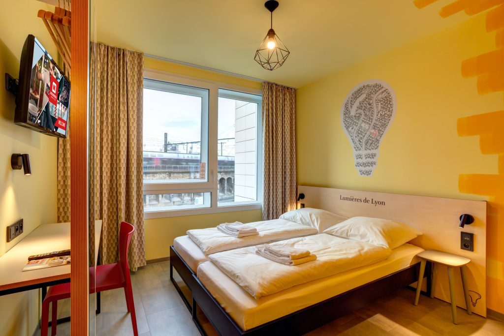 Chambre double lumineuse au MEININGER Hotel Lyon Centre Berthelot avec vue sur les rails
