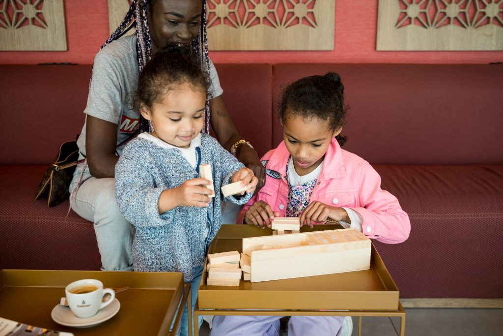Kids playing with wooden blocks in the kids’ area at MEININGER Hotel Marseille Centre La Joliette