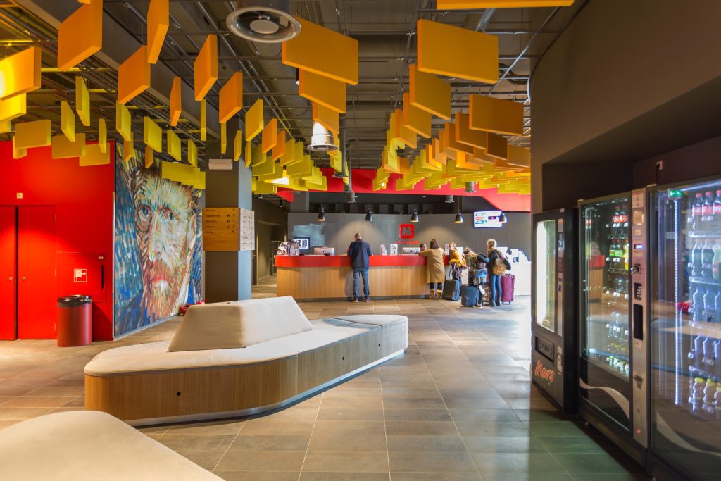 MEININGER Hotel Amsterdam City West: hall dal design colorato e murale con l'autoritratto di Van Gogh