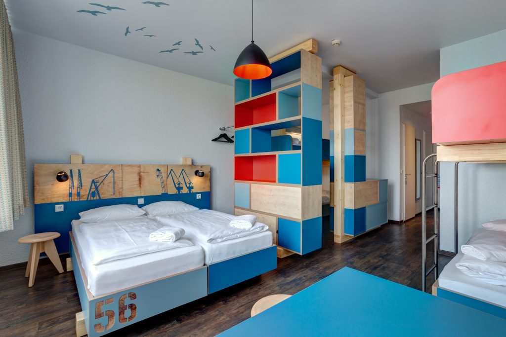 MEININGER Hotel Hamburg City Center : chambre avec deux lits simples et deux lits superposés à l'arrière-plan