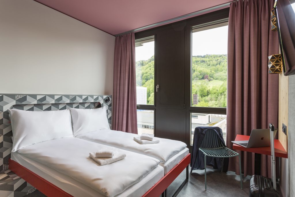 MEININGER Hotel Zürich Greencity: camera con due letti singoli e ampia finestra con vista sul parco