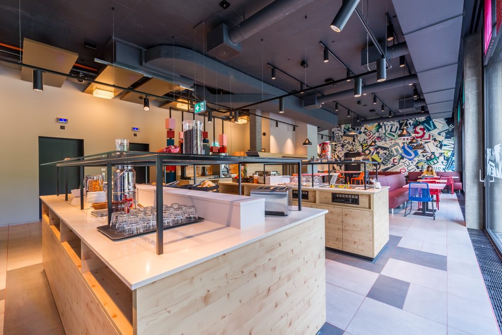 MEININGER Hotel Zürich Greencity: colazione a buffet con due isole, tavoli da pranzo sullo sfondo