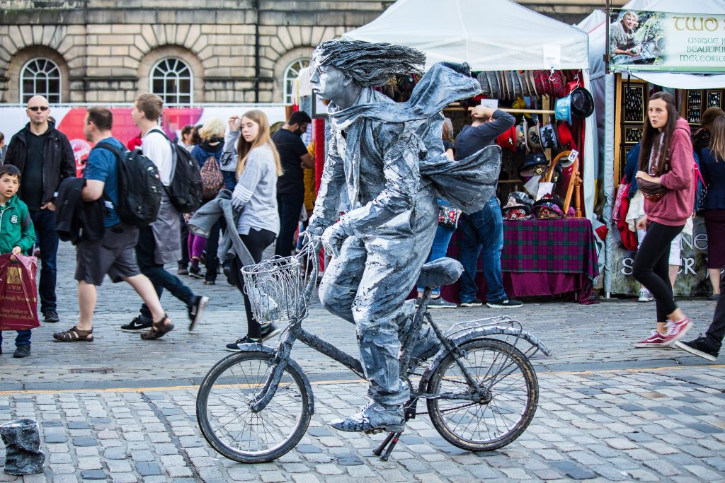 Fun facts Edinburgh: Street artist in Edinburgh painted as a silver statue on a bicycle