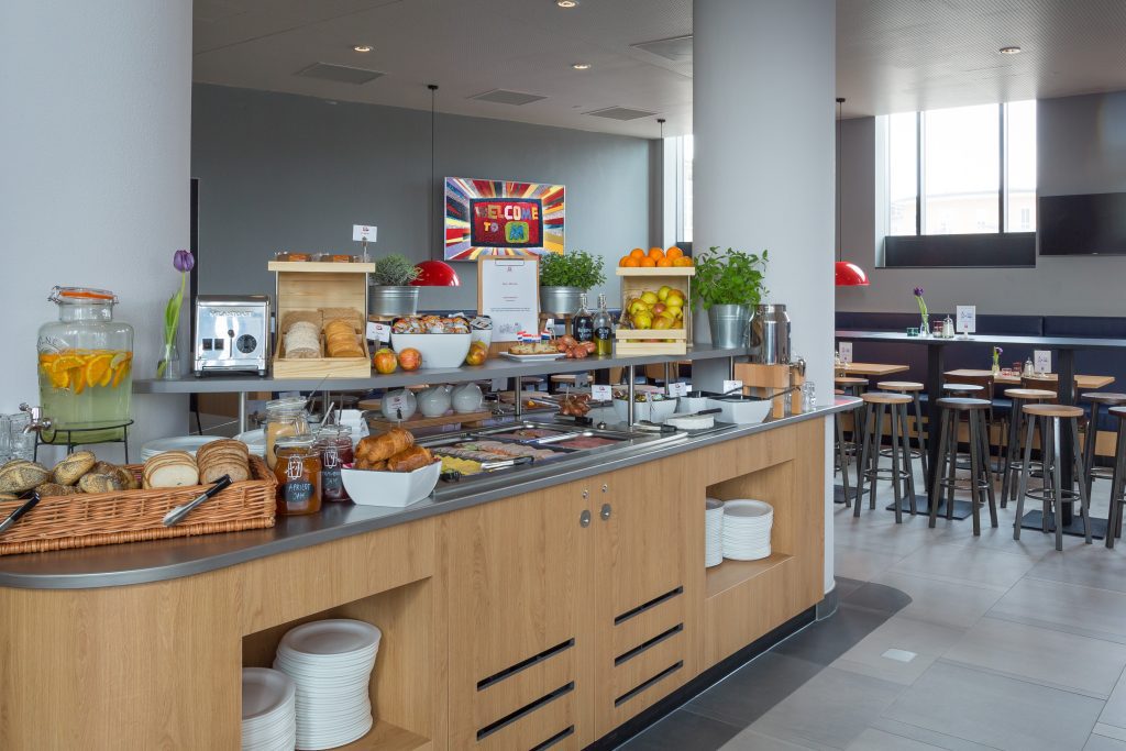Hotel breakfast area with wooden furniture and many food options