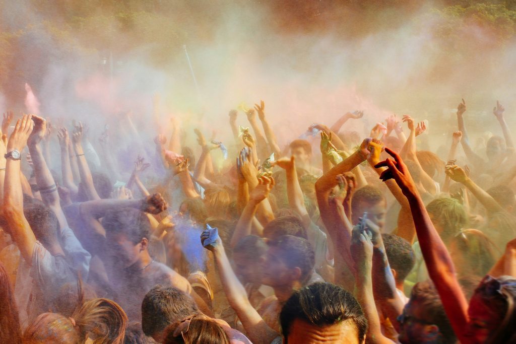 Barcelona music festivals: Festival crowd with raised hands in colorful smoke