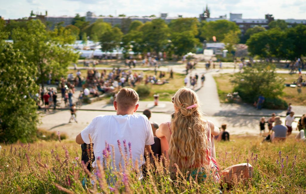 Free things to do in Berlin: Couple sitting on hill overlooking park in Berlin
