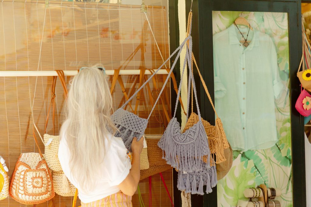 Shopping in Barcelona: Frau schaut sich Makramee-Taschen in einem Shop in Barcelona an
