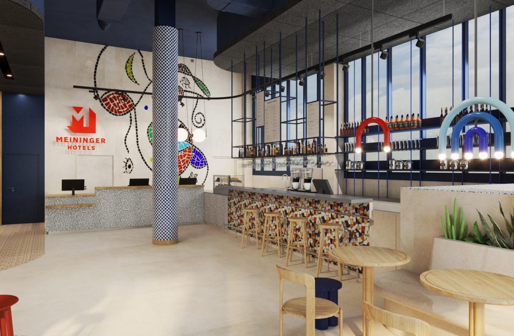 Hotelbar mit dem MEININGER Hotels Logo an der Wand, dekoriert mit Barhockern und blauem Hintergrund