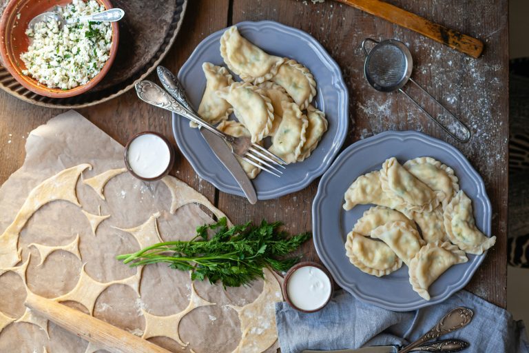 pierogi on two dishes and the dough in the making