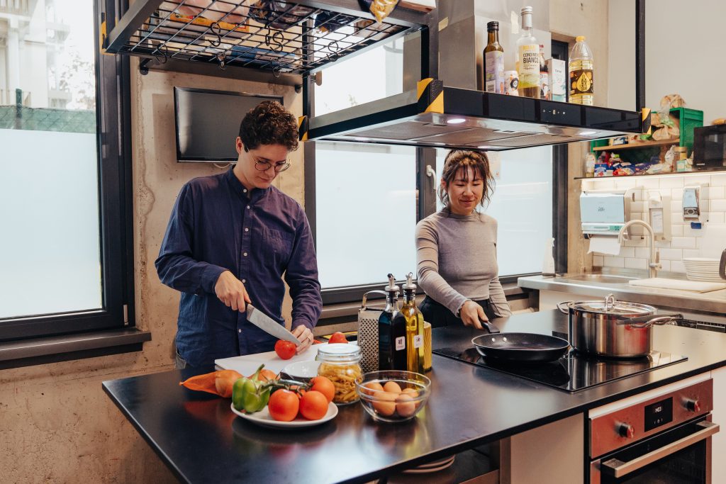 Two guests cooking together in the shared guest kitchen