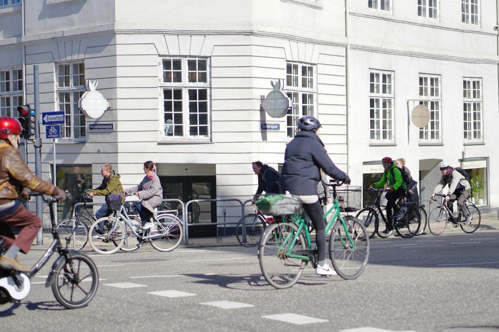 Fahrradverleih in Kopenhagen: Radfahrer fahren über eine stark befahrene Kreuzung