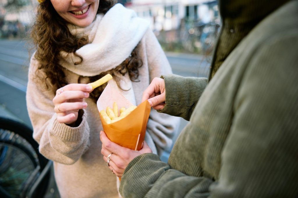 Brüssel für Alleinreisende: Zwei Freundinnen teilen eine Portion Frites in Brüssel