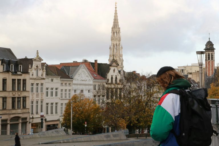 A backpacker from behind with historical building and church on the background