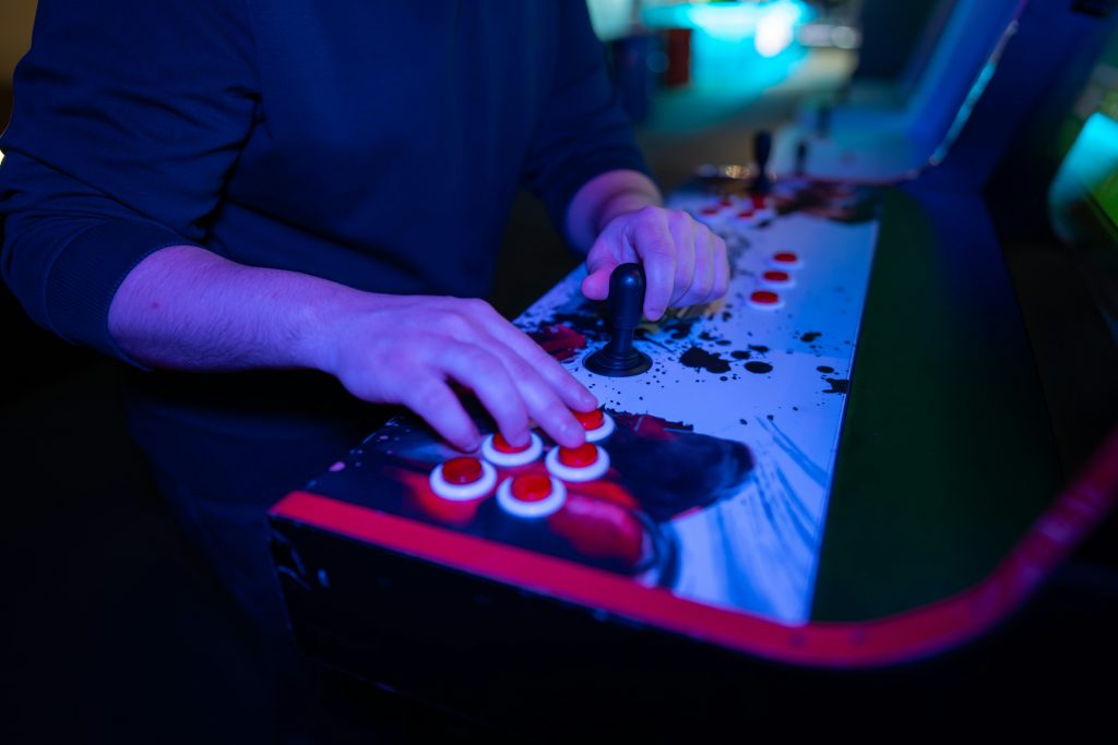 Gaming Conventions Europa: Hände an einem Arcade-Controller auf einer Gaming-Convention