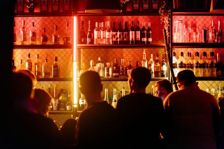 people sitting at the bar with neon lights