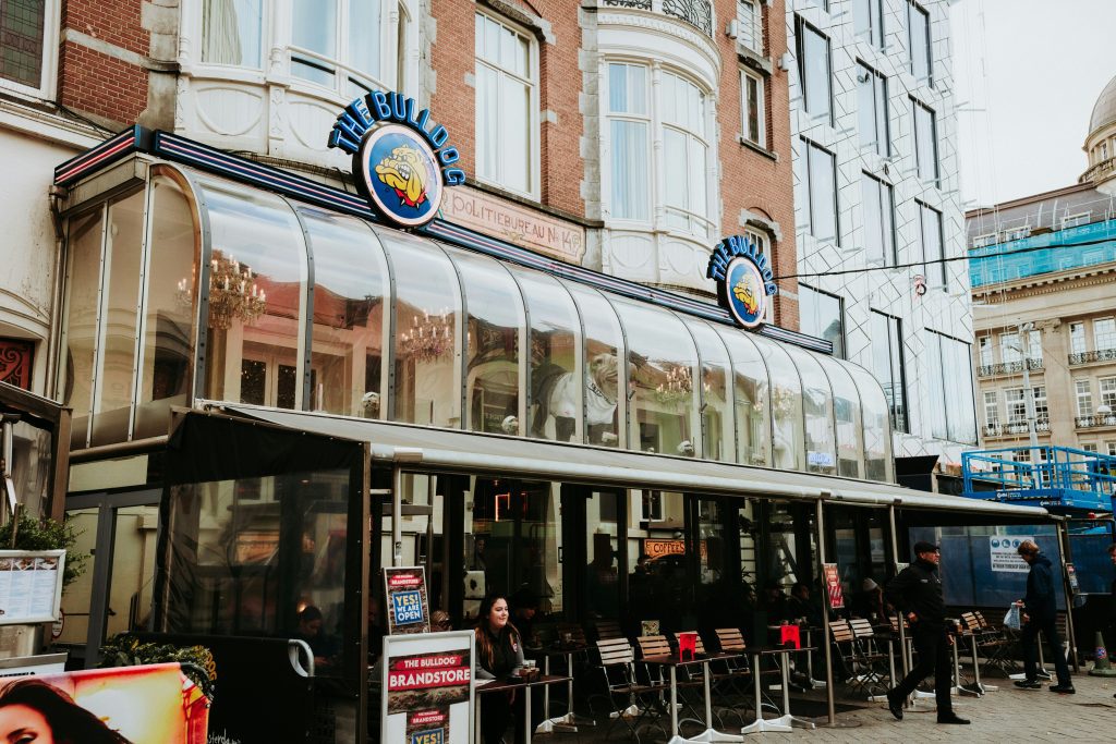 Best coffee shops in Amsterdam: The Bulldog coffeeshop facade on with glass exterior