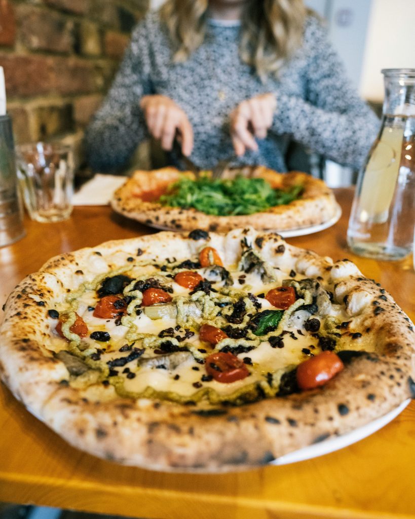 Les meilleurs restaurants végans à Berlin : des personnes en train de déguster une pizza végane