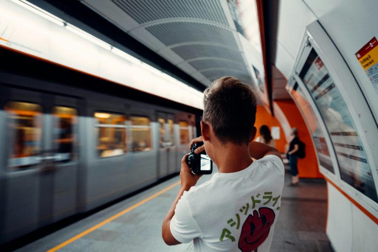 Guy from the back taking a photo of the metro train
