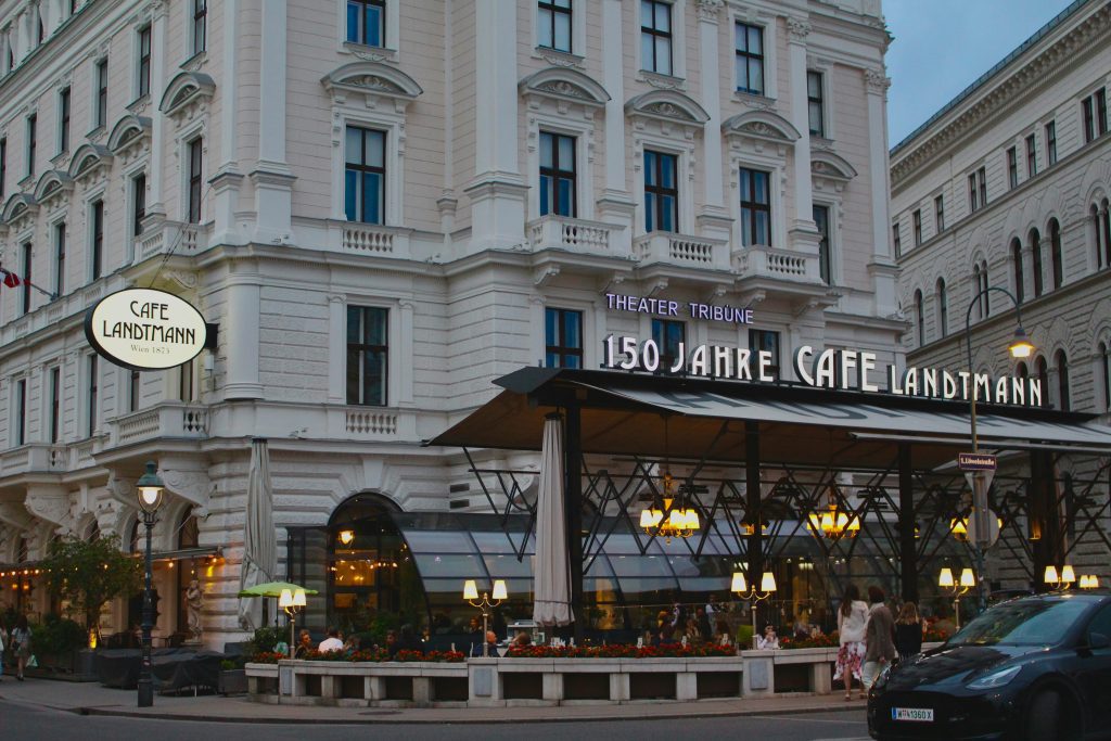 Instagram Wien: Beleuchtete Fassade und Terrasse des Café Landtmann in der Wiener Innenstadt