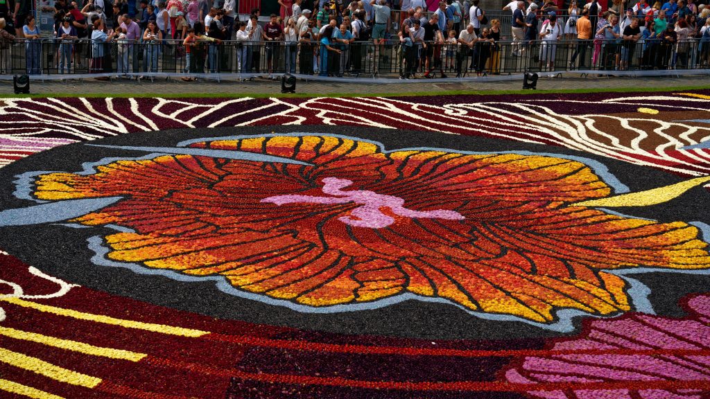 Flower carpet Brussels: Close-up of the Brussels flower carpet with a floral pattern and crowds behind